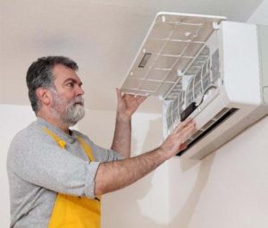 A technician installing a mini split AC system
