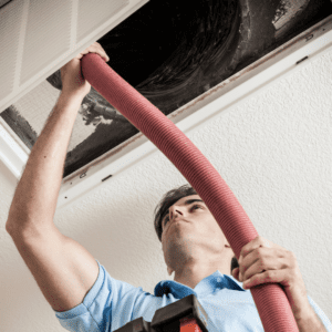 A technician performing air duct cleaning in Tallahassee